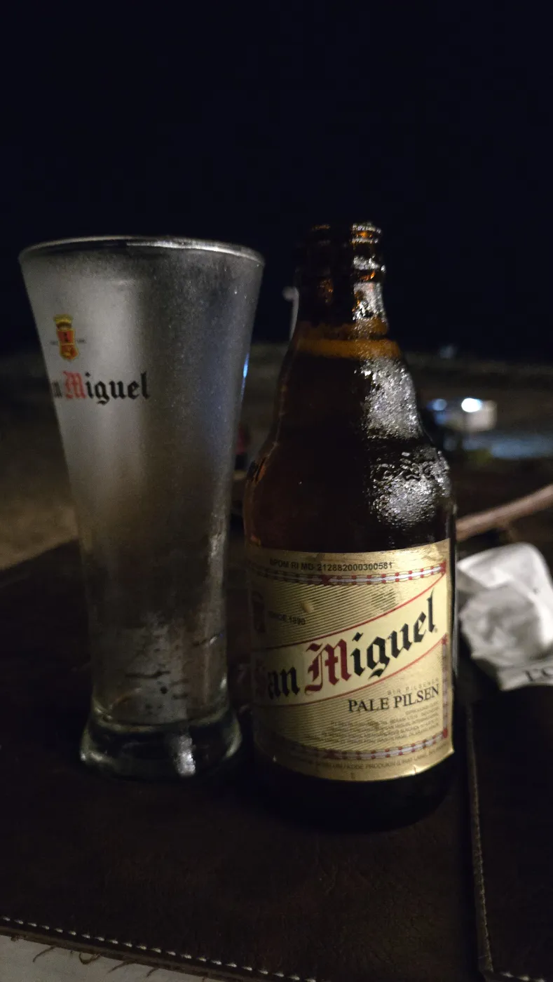 밤 해변 테이블 위 산미겔 병맥주와 성에 낀 잔