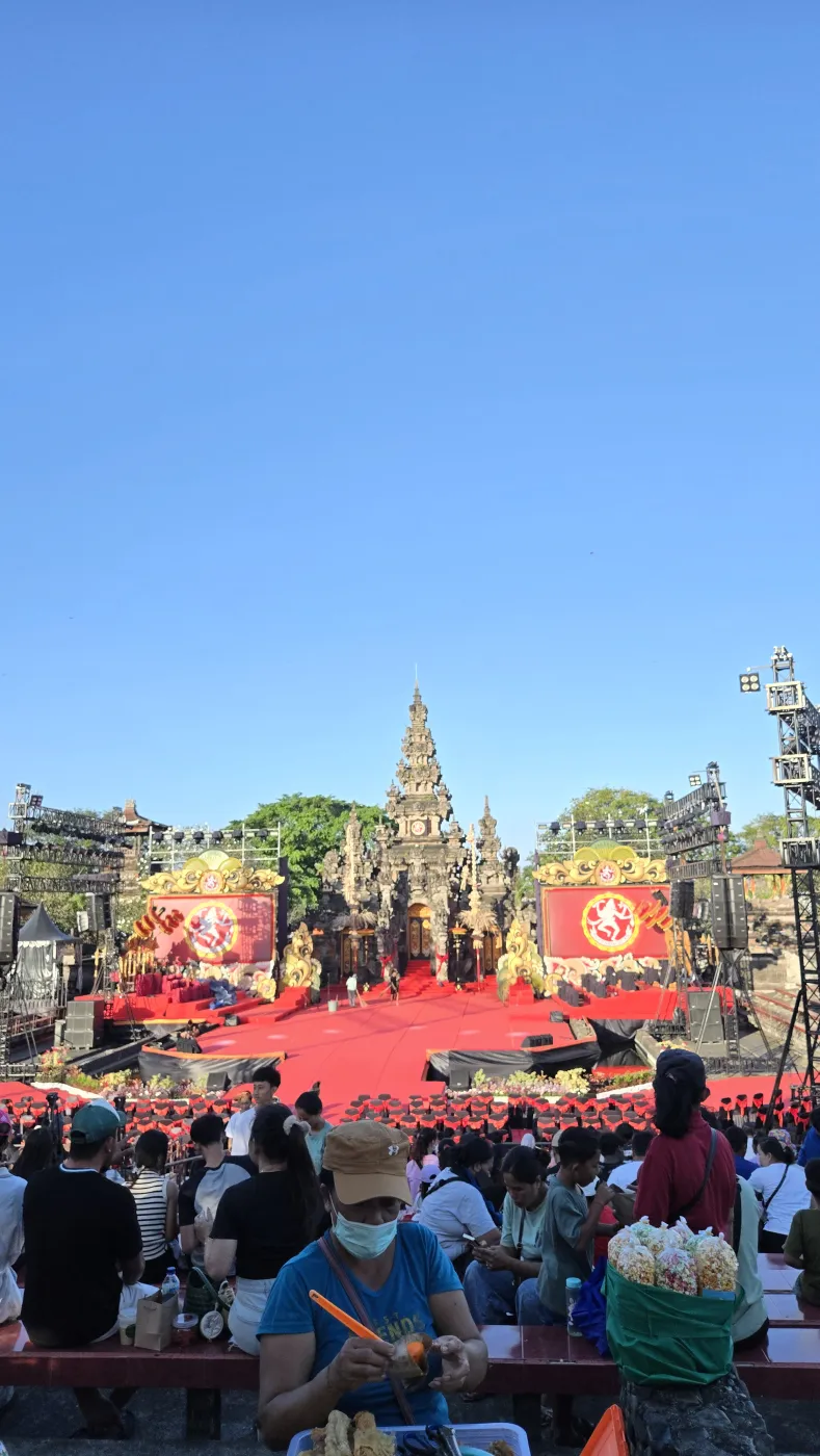 Bali Art Center 축제 메인 무대 — 붉은 무대와 사원 배경, 관객, 파란 하늘