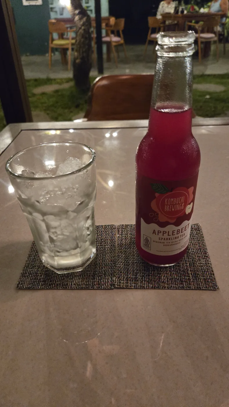 Blend 카페 밤 정원 테이블 위 애플비트 스파클링 콤부차 병과 얼음잔