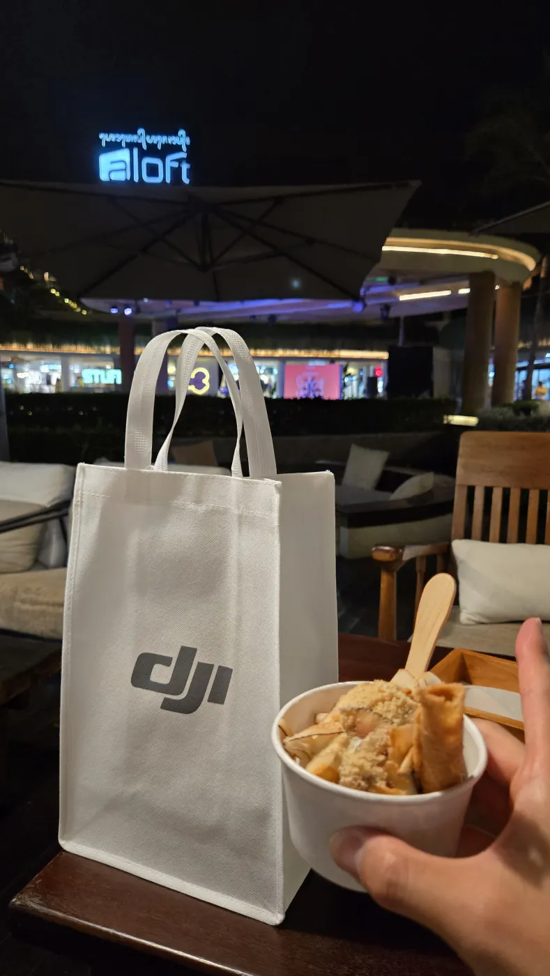 비치워크 몰 야경 — DJI 쇼핑백과 손에 든 아이스크림 컵, aloft 네온 사인