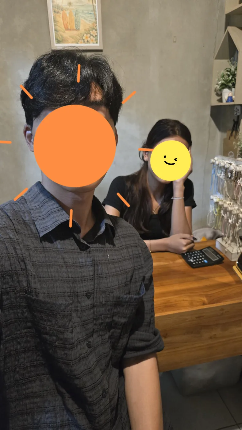 기념품 가게 계산대에서 Ica와 함께 찍은 셀카 — 두 사람의 얼굴은 스티커로 가려져 있다